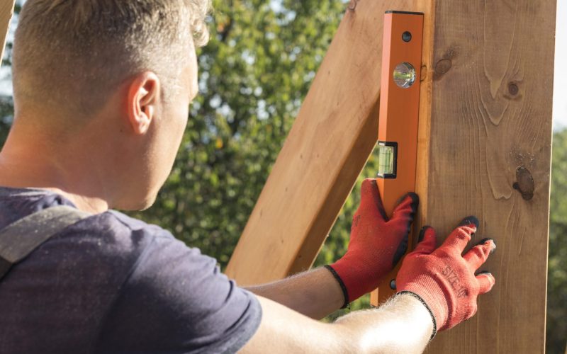 carpenter-man-taking-measures-wood-plank